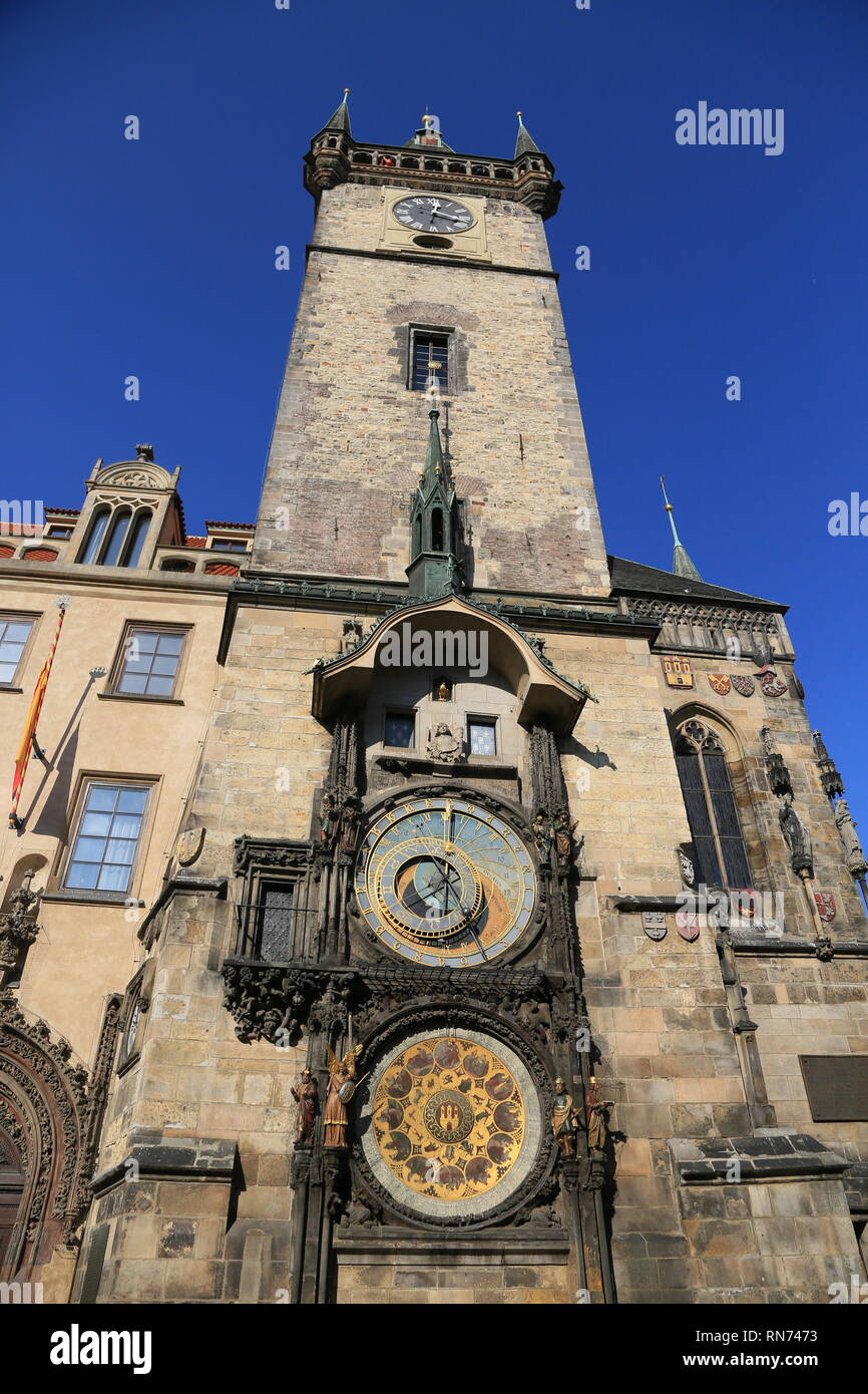 A view from the bottom of Prague`s Astronomical Clock standing tall and proud in the height of summer with a beautiful blue sky in the background. Stock Photo